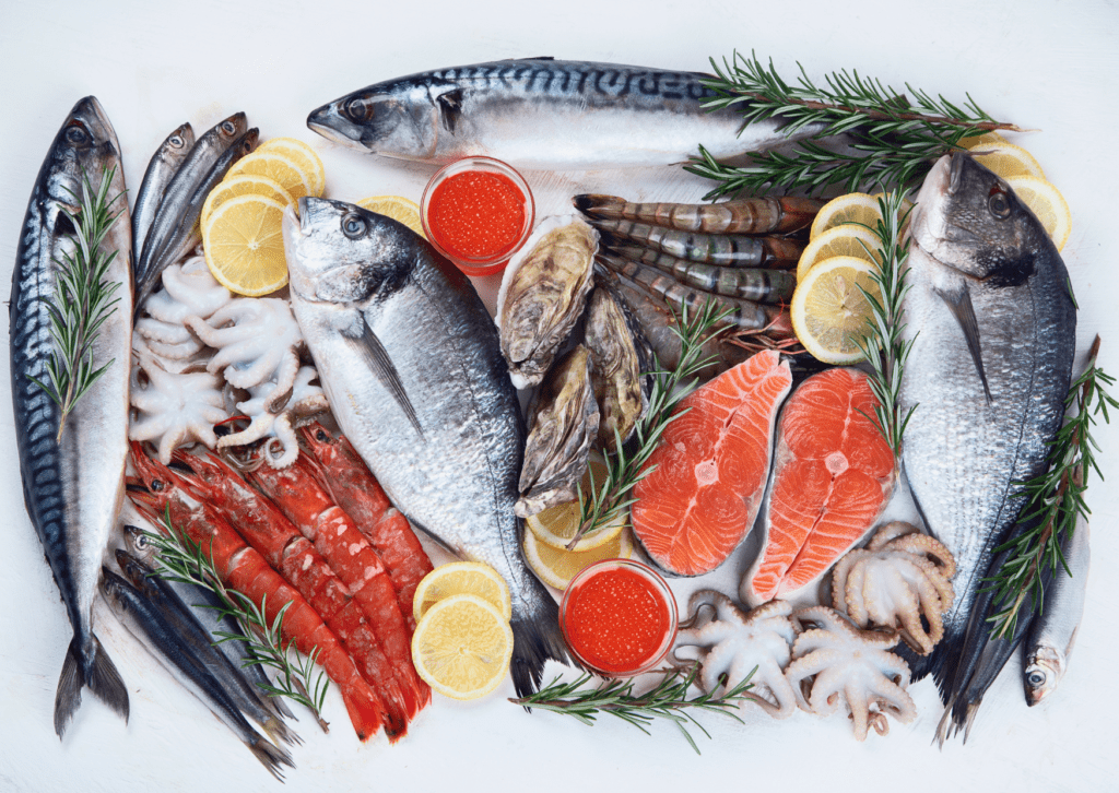 Assorted arrangement of seafood including 3 large fish, salmon steaks, crayfish and octopus. Garnishments of rosemary, lemon slices and salmon roe are mixed in with the seafood.