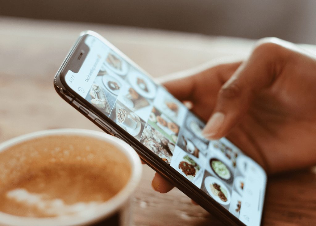 Close up of a hand holding a phone as if the person is scrolling with their thumb.