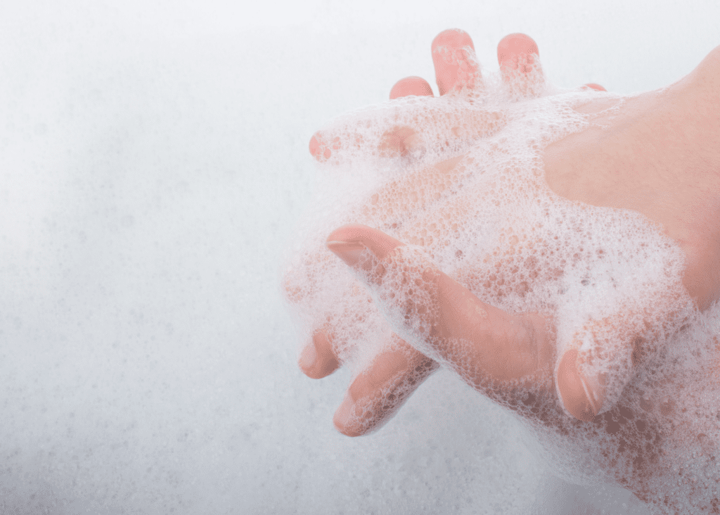 A child's hands covered in white soapsuds