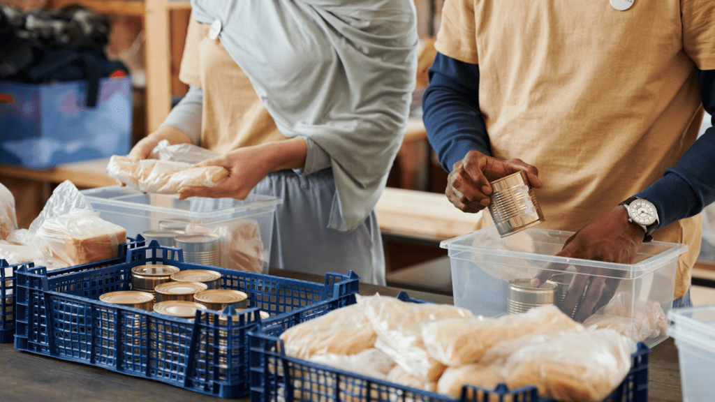 Two people packing food stuffs for a charity.