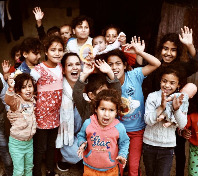 A crowd of children around an adult woman