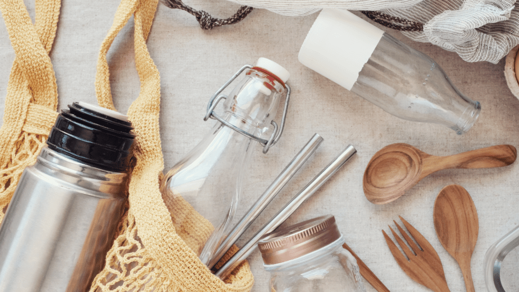 Image of glass containers, wooden spoons, cloth bags, metal straws, and a metal thermos.