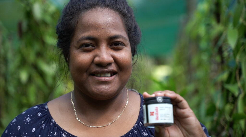 A Tongan Heilala manager, Sela, holding a jar of vanilla paste