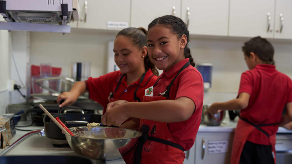 two school children cooking in their school kitchen