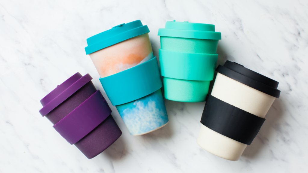 An assortment of colourful reusable coffee cups.