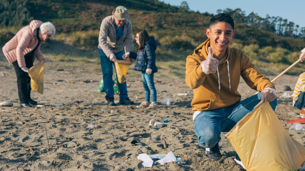 A group of people collecting rubbish on a beach.