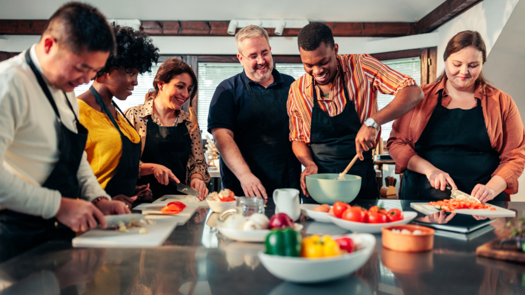 A group of people around a table joining in a cooking class.