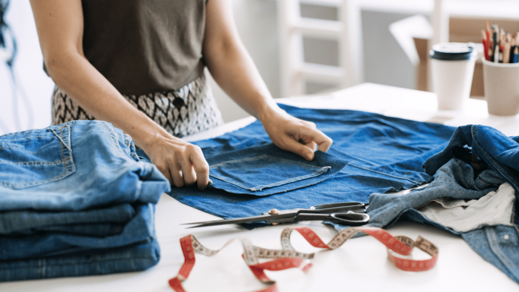 Denim upcycling ideas, repair and using old jeans. Woman repairing old jeans.