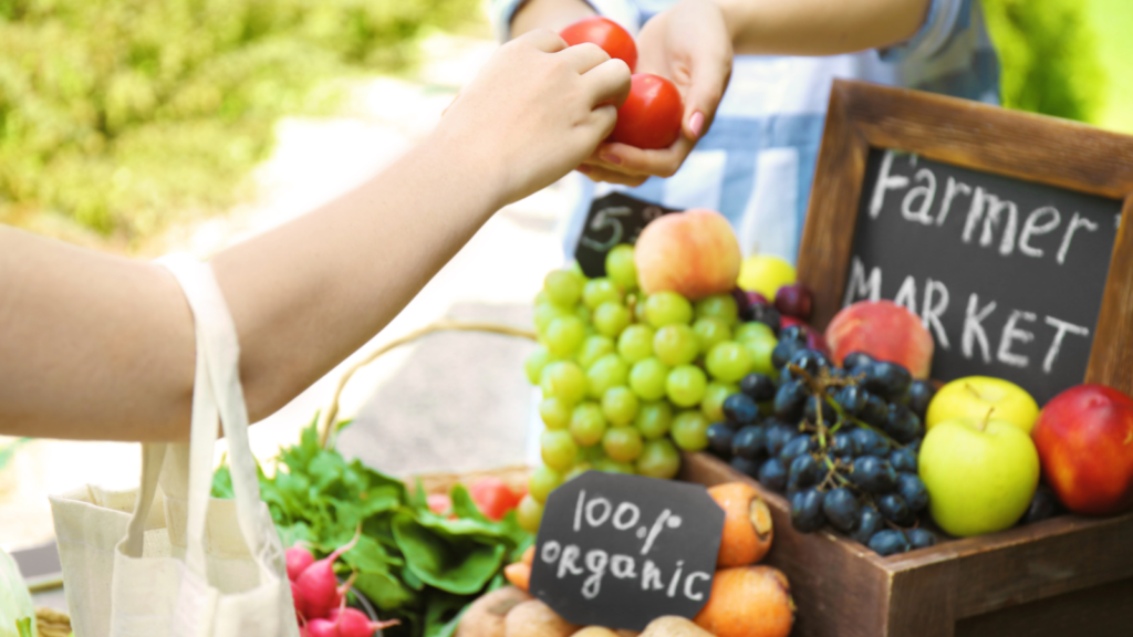 A person buying produce at a local farmers' market.