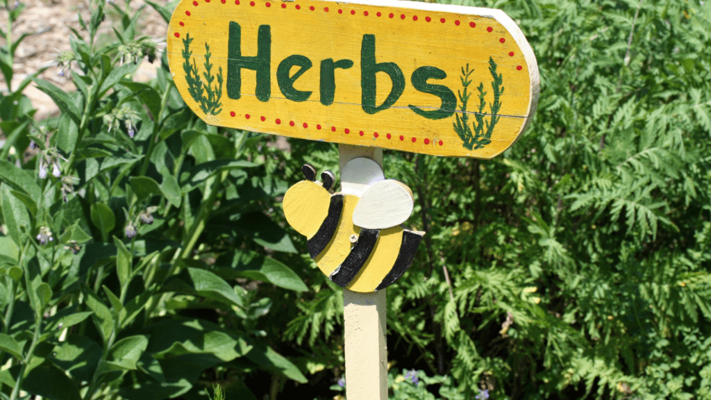 A herb garden with a Herbs sign and a picture of a bee.