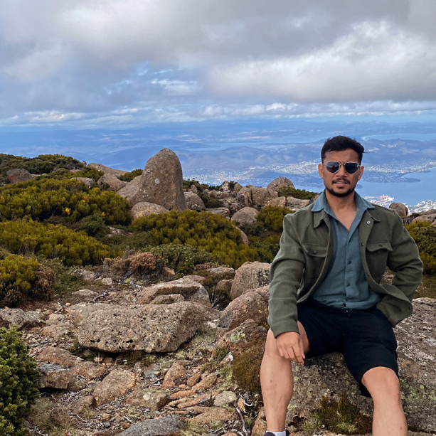 A man sitting on a rock above a scenic view