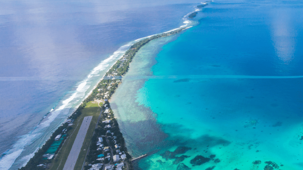 An aerial view of Tuvalu with the ocean encroaching on either side.